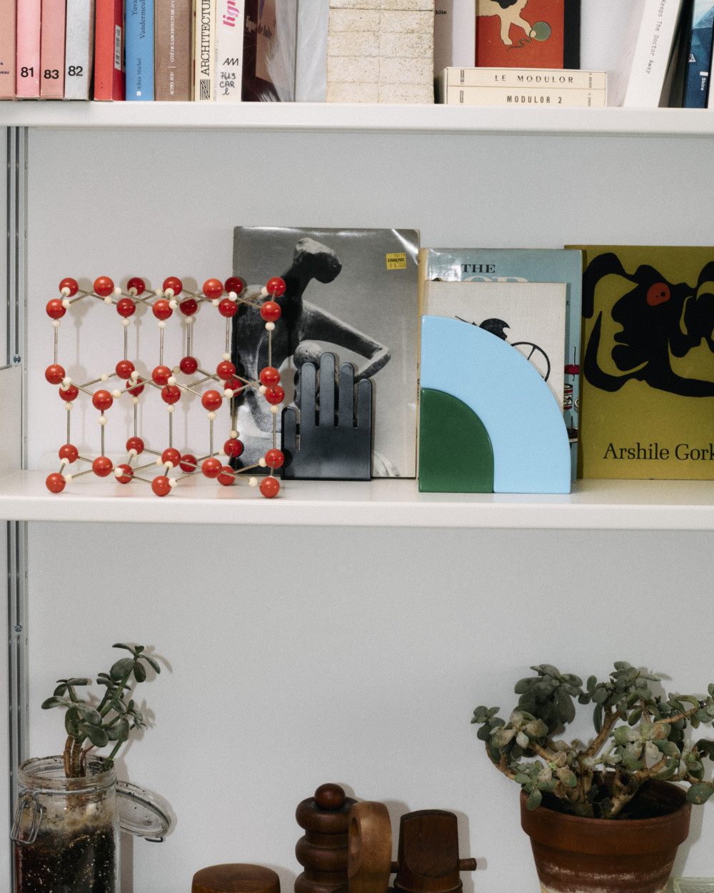 A composition of Little Family forms by nara.world used as sculptural bookends on a curated bookshelf with art books and objects