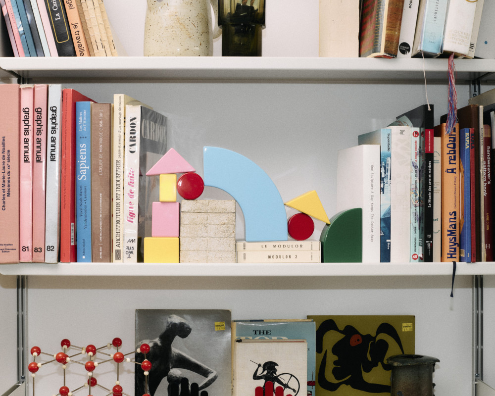 Playful units from the Little Family series by nara.world arranged as sculptural bookends on a bookshelf