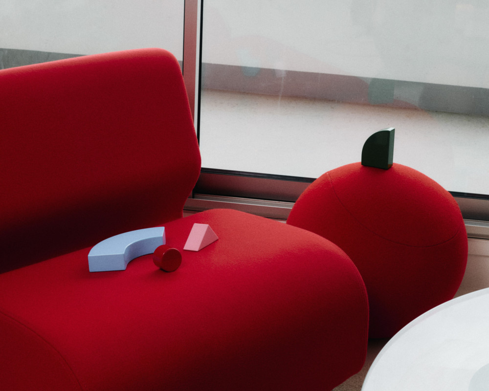 Individual units from the Little Family collection by nara.world placed on a red lounge chair in a modern interior setting